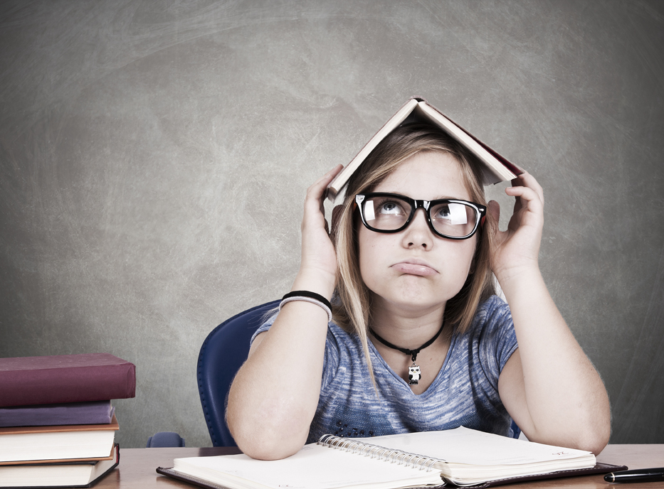 niña estudiando con cara de aburrimiento