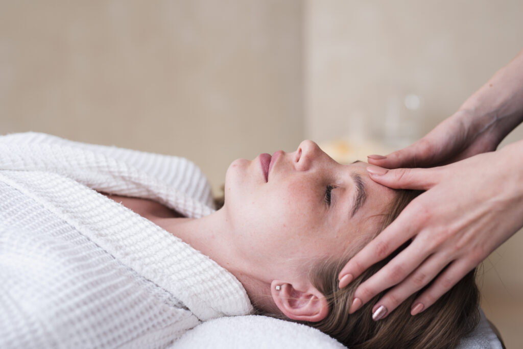 Mujer recibiendo masaje facial después de sesión de acupuntura en Espai Deva