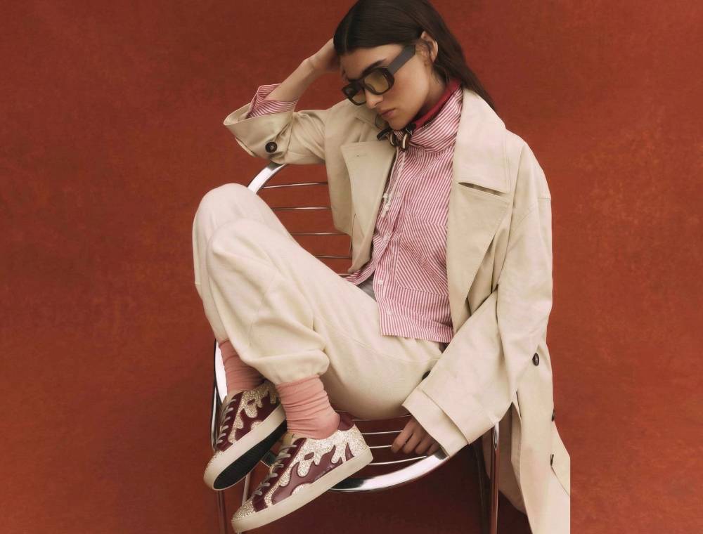 modelo con zapatillas con glitter granate con detalles de llamas de Gamin sentada en una silla